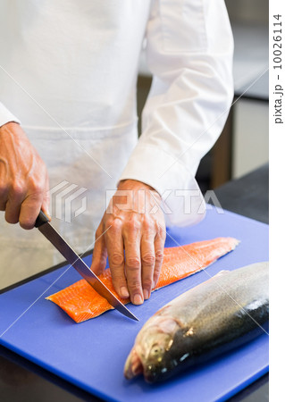 Closeup mid section of a chef cutting fish Closeup mid section of a chef cutting fish 10026114
