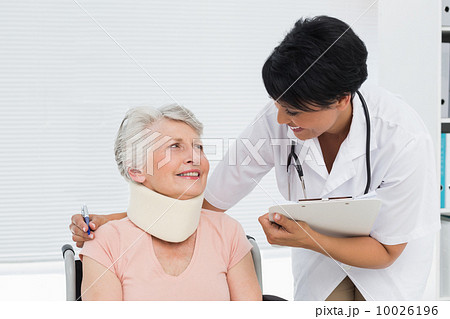 Doctor talking to a senior patient with cervical collar 10026196