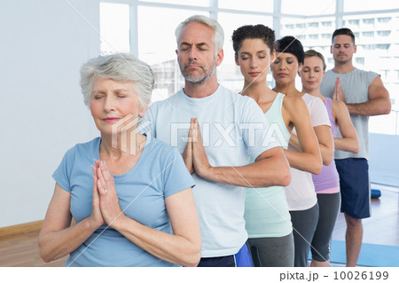 Sporty people with eyes closed and joined hands 10026199