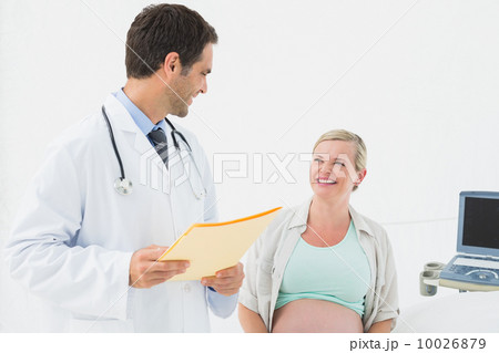 Smiling pregnant woman having a check up with doctor 10026879