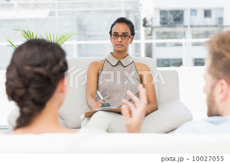Therapist listening to unhappy couple and taking notes 10027055