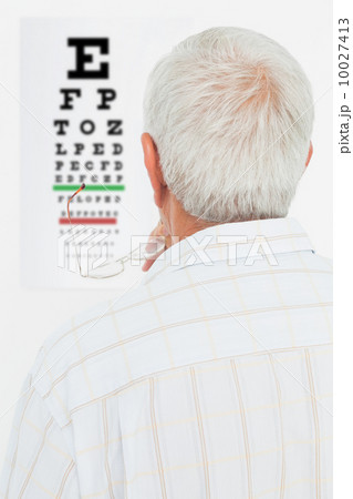 Rear view of a senior man looking at eye chart Rear view of a senior man looking at eye chart 10027413