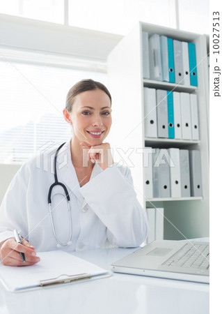 Doctor sitting at desk in clinic 10027513