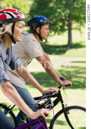 Couple riding bicycles in a park Couple riding bicycles in a park 10027594