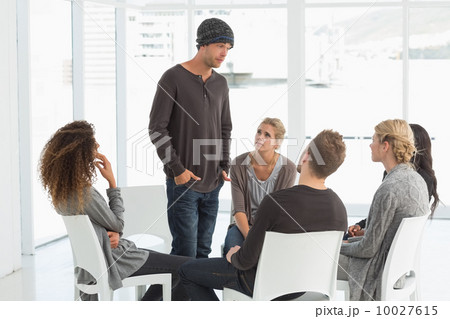 Rehab group listening to man standing up introducing himself Rehab group listening to man standing up introducing himself 10027615