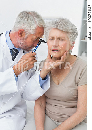 Male doctor examining senior patient's ear Male doctor examining senior patient's ear 10027683