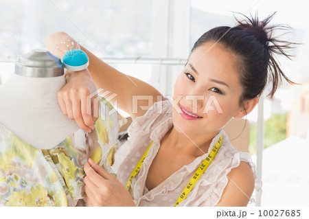 Beautiful female fashion designer working on dress 10027685