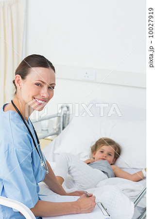 Doctor with clipboard attending sick girl 10027919