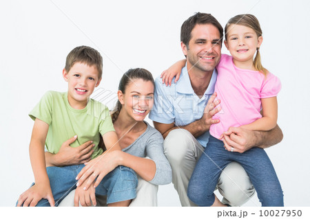 Cute family posing and smiling at camera together 10027950