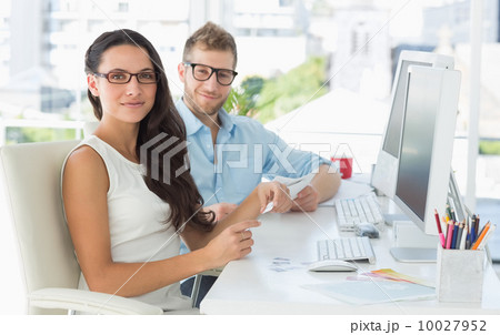 Creative partners looking at camera at their desk Creative partners looking at camera at their desk 10027952
