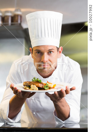 Smiling male chef with cooked food in kitchen 10027992