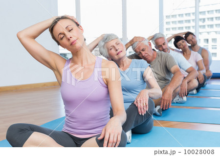 Class stretching neck in row at yoga class 10028008