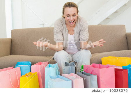 Excited woman looking at many shopping bags 10028076
