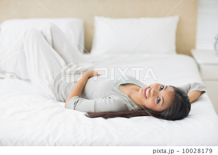 Young girl lying on bed looking at camera 10028179