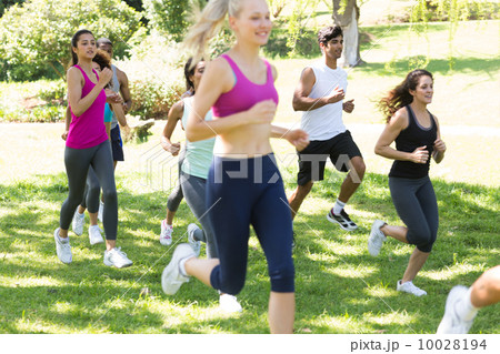 Athletes running on grassy land 10028194