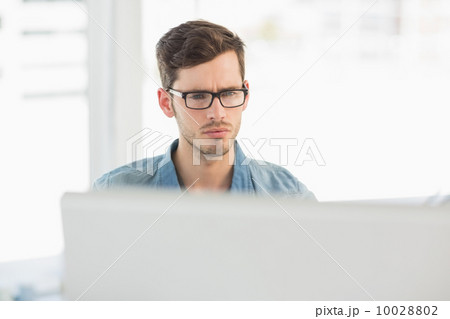 Concentrated young male artist using computer 10028802