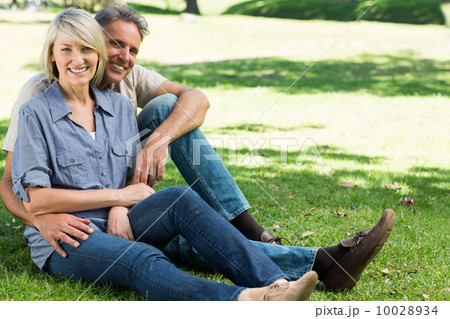 Happy couple sitting in park Happy couple sitting in park 10028934