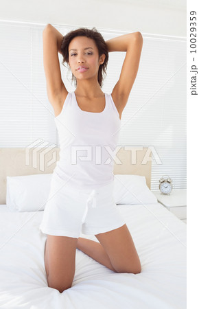 Sexy brunette kneeling on her bed posing Sexy brunette kneeling on her bed posing 10029359