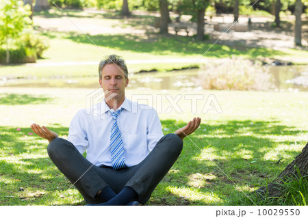 businessman meditating in park businessman meditating in park 10029550