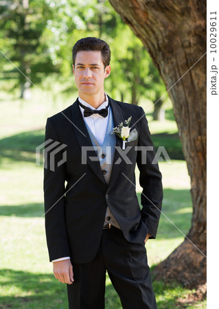 Confident bridegroom in tuxedo at garden Confident bridegroom in tuxedo at garden 10029611