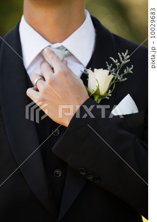Mid section of flowers on lapel of male 10029683