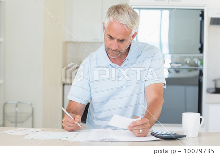 Concentrating man working out his finances 10029735
