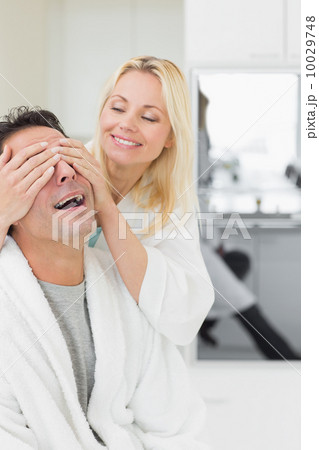 Smiling woman covering happy mans eyes Smiling woman covering happy mans eyes 10029748