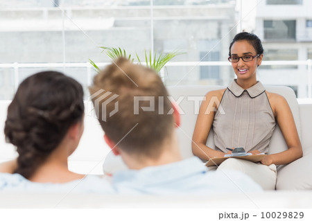 Therapist smiling at couple on the couch 10029829