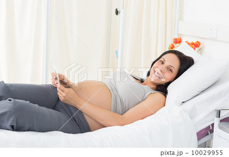 Happy pregnant woman lying in bed 10029955