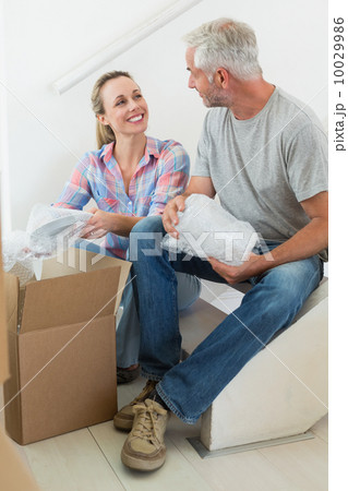 Happy couple unpacking cardboard moving boxes Happy couple unpacking cardboard moving boxes 10029986