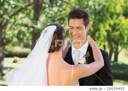Groom embracing woman in garden Groom embracing woman in garden 10030492