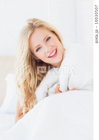 Pretty young woman covering herself with duvet 10030507