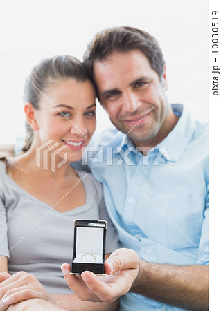 Cheerful young couple getting engaged on the sofa 10030519