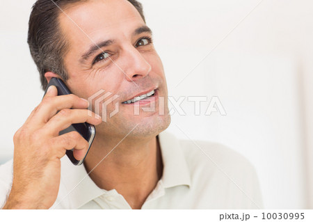Closeup portrait of a smiling man using mobile phone 10030995