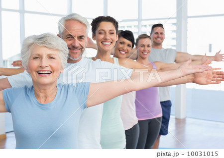 Portrait of fitness class stretching hands in row 10031015