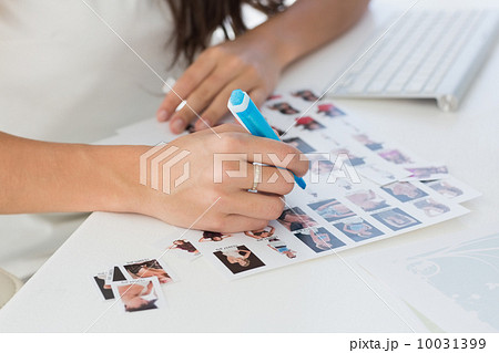 Editor working at her desk marking a contact sheet 10031399