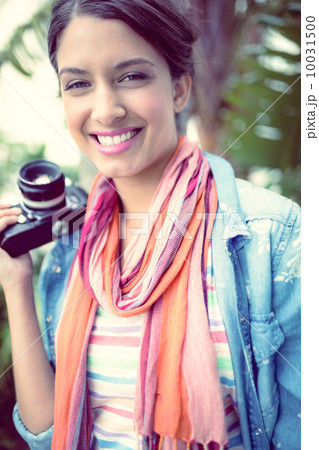 Cheerful photographer standing outside smiling at camera 10031500