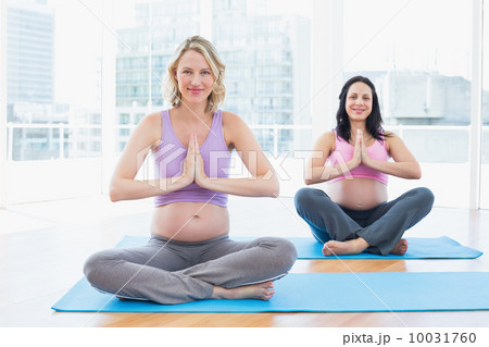Happy pregnant women in yoga class in lotus pose Happy pregnant women in yoga class in lotus pose 10031760