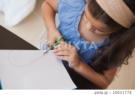 High angle close-up of a girl cutting chart paper 10031778