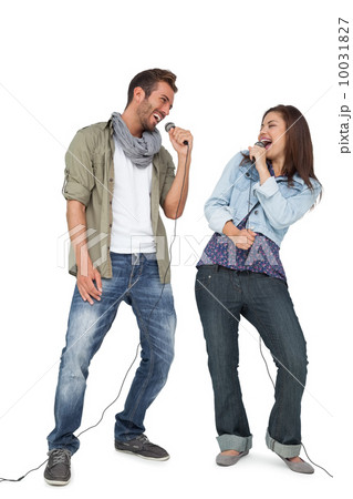 Full length of a couple singing into microphones Full length of a couple singing into microphones 10031827