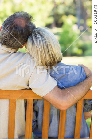 Couple relaxing on bench in park 10031978