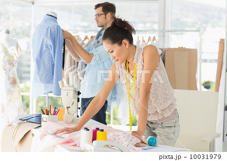Fashion designers at work in bright studio 10031979