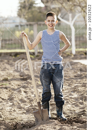 happy boy working with shovel in garden 10032622