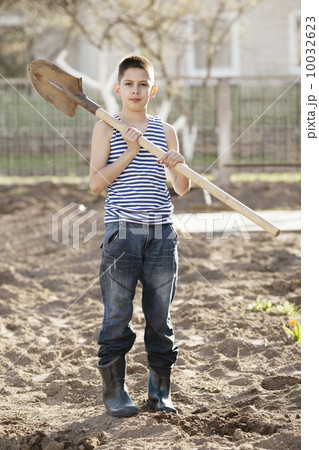 happy boy working with shovel in garden happy boy working with shovel in garden 10032623