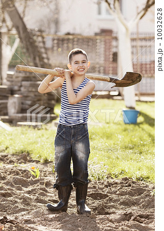 happy boy working with shovel in garden happy boy working with shovel in garden 10032628