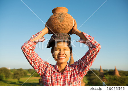 Asian traditional female farmer carrying clay pot Asian traditional female farmer carrying clay pot 10033566