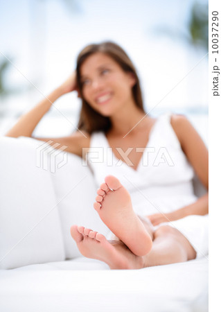 Woman feet - barefoot woman relaxing in sofa Woman feet - barefoot woman relaxing in sofa 10037290