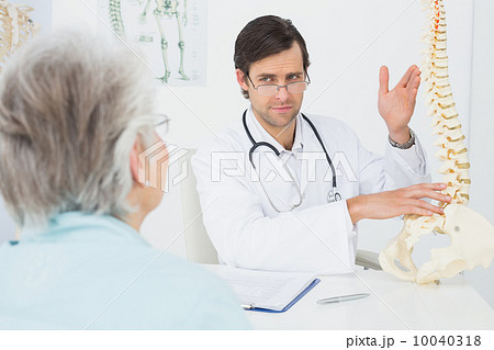 Male doctor explaining the spine to a senior patient 10040318