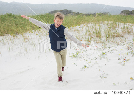 Cheerful boy running at beach 10040321