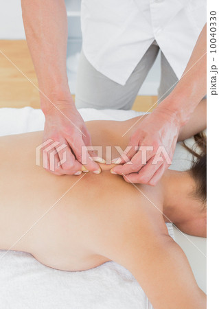 Male physiotherapist massaging woman's back 10040330